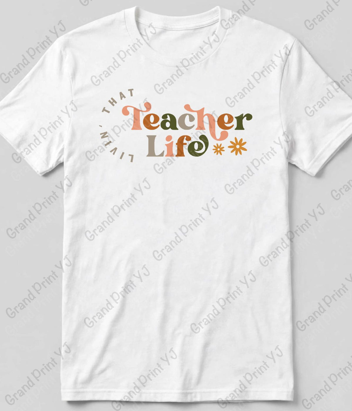 A white short-sleeve t-shirt with a graphic on the chest that reads 'THAT Teacher Life' in orange and olive green lettering, surrounded by a circular 'TEACHER' text and small starburst accents. The t-shirt is displayed flat against a light gray background with diagonal watermarks.