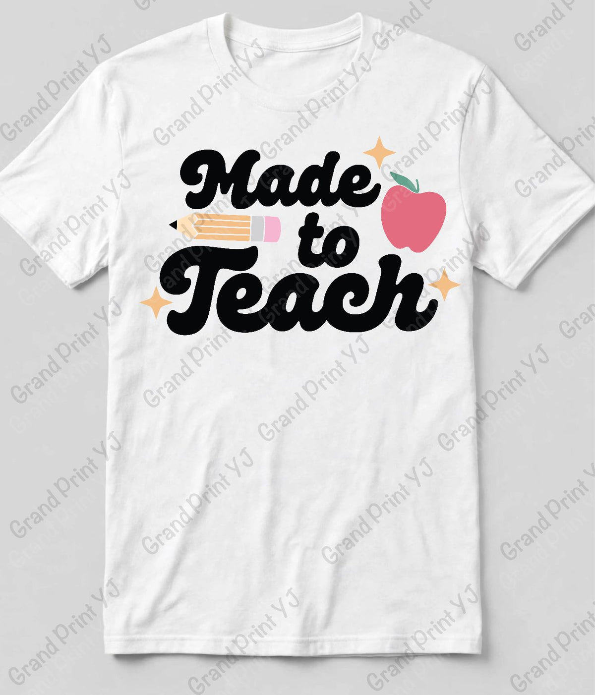 A white short-sleeve crewneck t-shirt with a 'Made to Teach' graphic on the chest. The graphic features the words 'Made to Teach' in black script, accompanied by a pink apple with a green stem, a pencil, and small yellow sparkles.