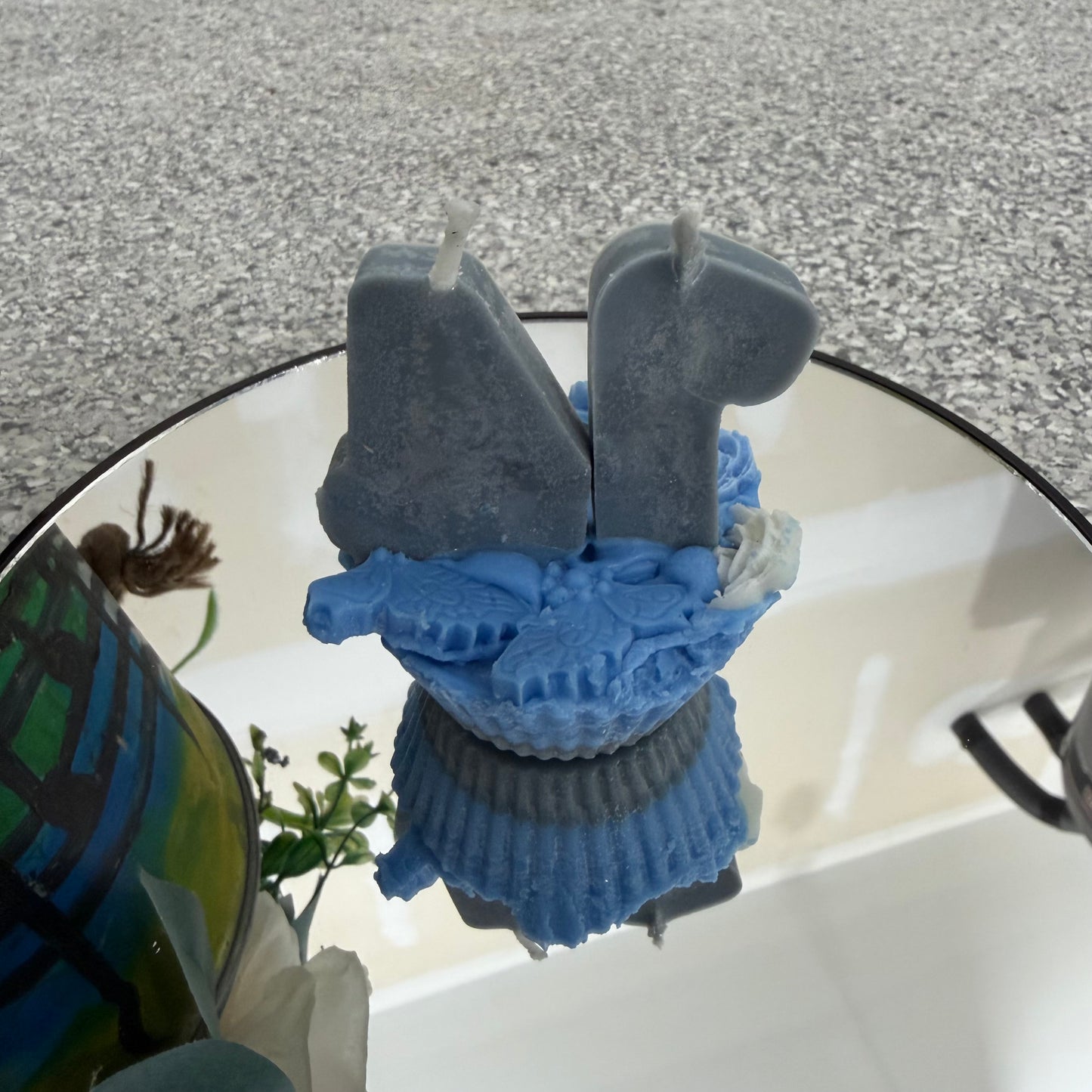 Blue and gray silicone mold on a reflective surface with a blurred background