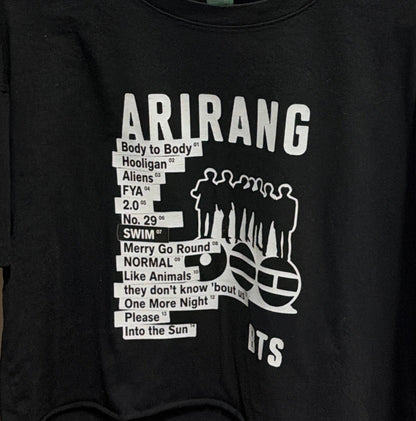 Black t-shirt with white text and graphics on a hanger against a white door background