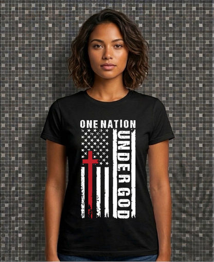 Person wearing a black t-shirt with an American flag and cross design, text 'One Nation Under God' on a patterned wall background.